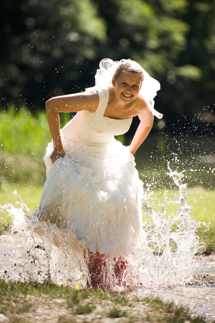 bride trashing her dress with jumping in the water